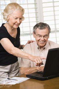 Mature Caucasian couple looking at laptop.